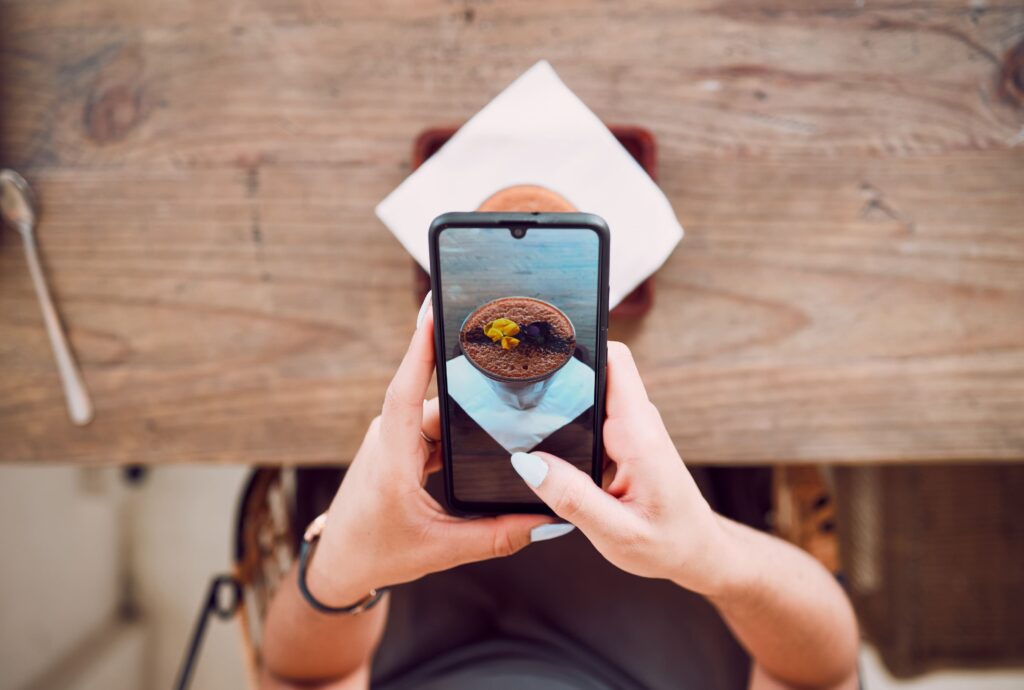 woman-phone-screen-and-taking-photograph-of-coffe-2023-11-27-05-09-23-utc